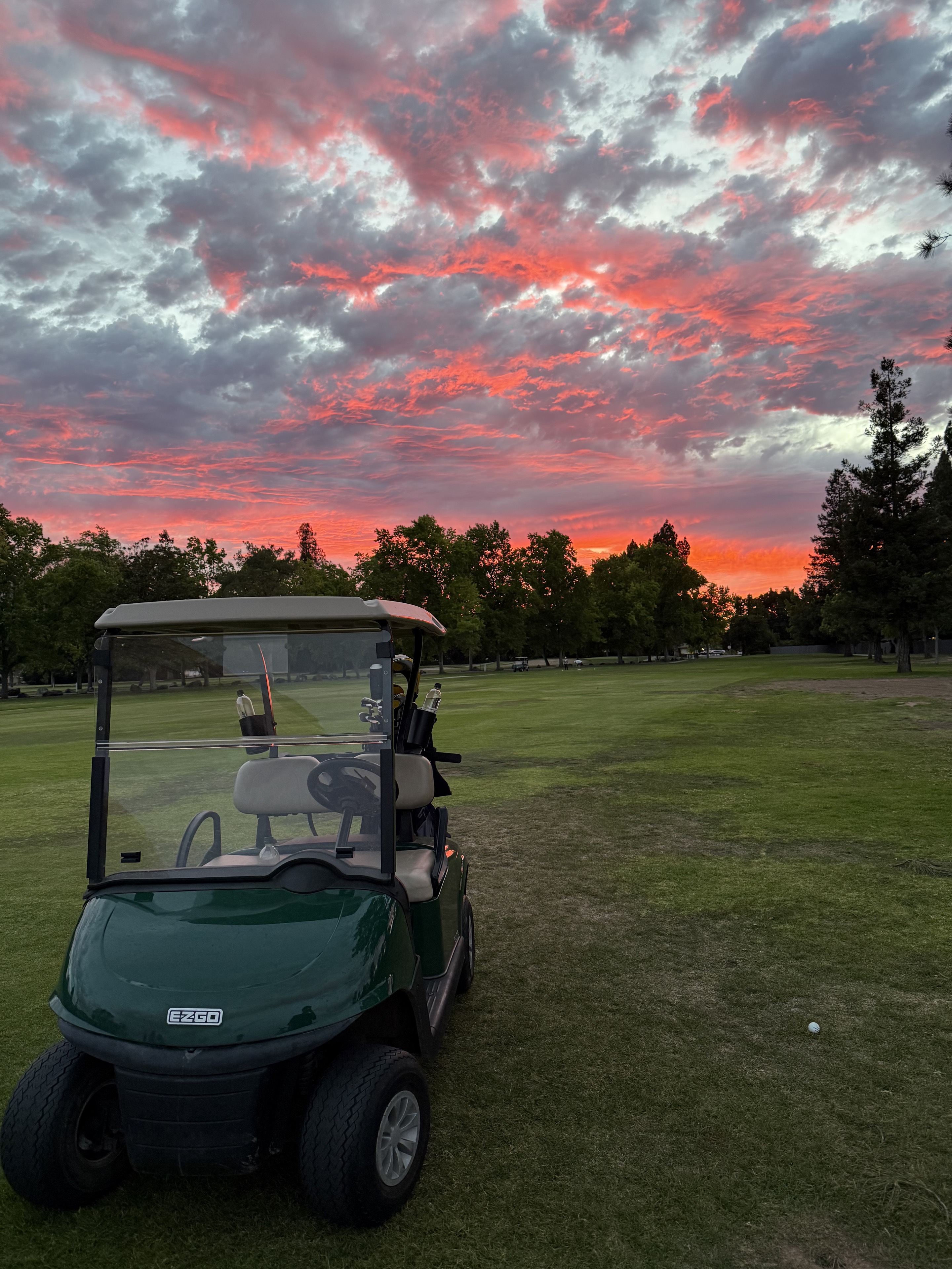 A golf cart beneath a vivid sunset